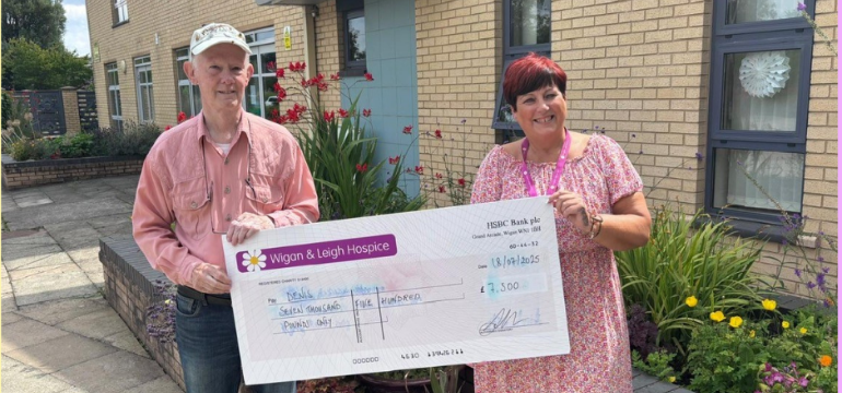 Our lottery player Denis - standing with a £7,500 cheque. He won the money in our summer bumper lottery draw.