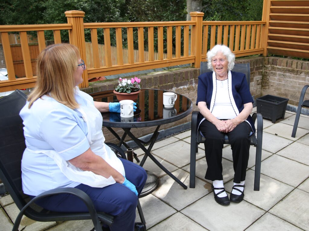 Hospice in your Home - a member of the team and a patient share a coffee.