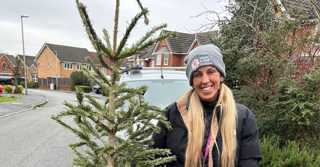 Lindsey Butler, Fundraising and Community Engagement Manager, at Wigan & Leigh Hospice stood with a Christmas tree that's ready to be recycled.
