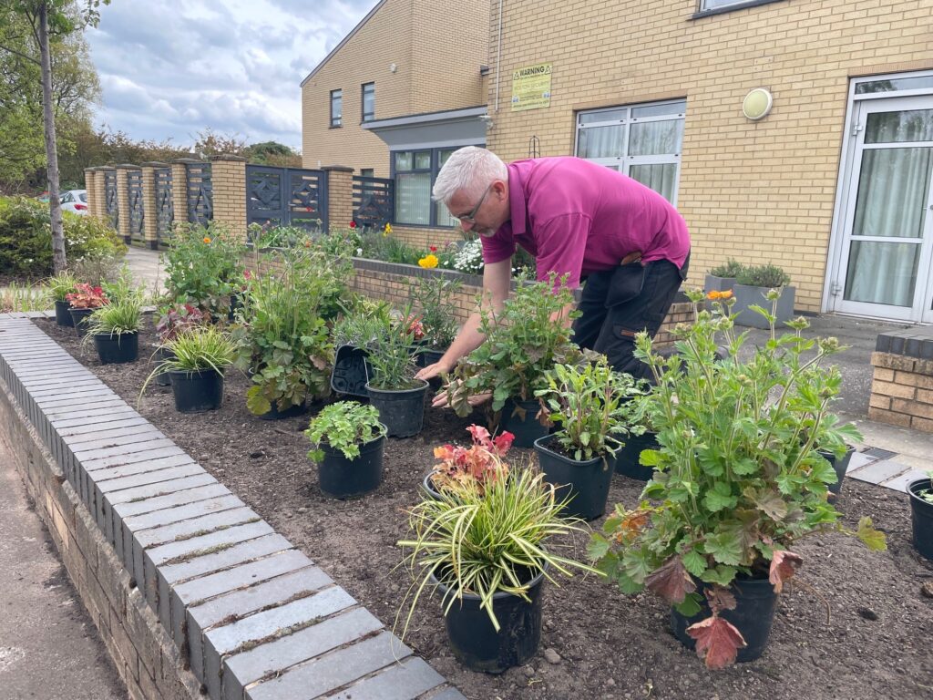 Jim Nicholson, Hospice Gardener at Wigan & Leigh Hospice. In the picture, Jim is planting plants in a flower bed.