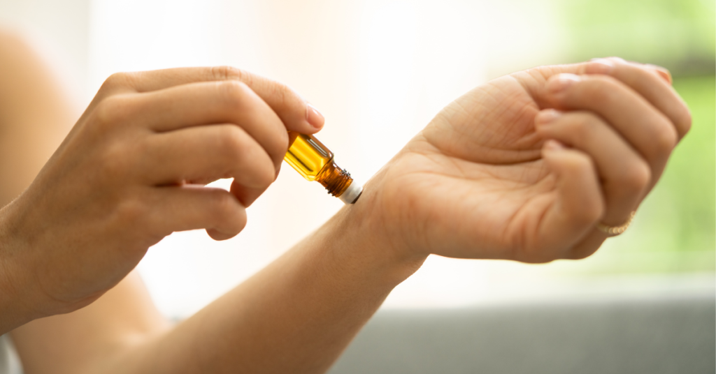 The image shows somebody using an aromatherapy scent stick on their own wrist.