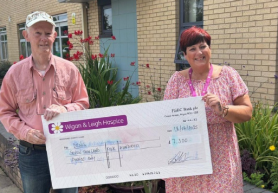 Our lottery player Denis - standing with a £7,500 cheque. He won the money in our summer bumper lottery draw.